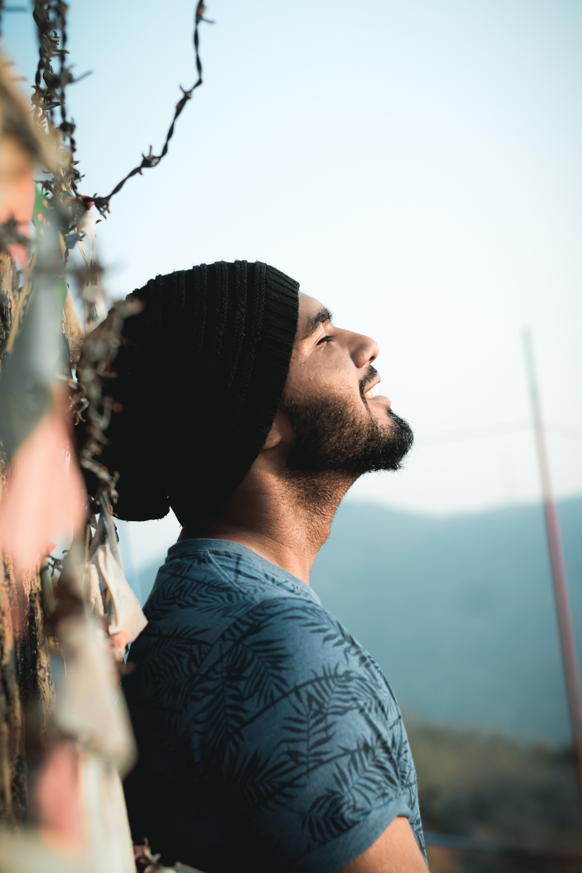 Calm smiling man leaning on wall in countryside